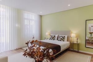- une chambre avec un lit et une grande fenêtre dans l'établissement Primeiro Quartel Apartments - 2, à Peso da Régua