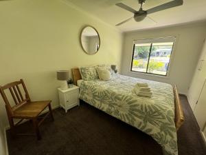 a bedroom with a bed and a chair and a window at Belford House in Myrtleford