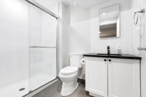 a white bathroom with a toilet and a shower at 14 minutes from downtown, brand new home in Ottawa in Ottawa