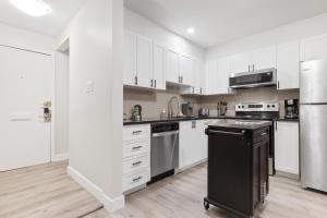 eine Küche mit weißen Schränken und einem schwarzen Kühlschrank in der Unterkunft 14 minutes from downtown, brand new home in Ottawa in Ottawa
