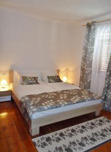 a bedroom with a bed and a window with curtains at Apartments Ana in Savudrija