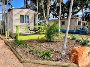 a small house with a yellow and green porch at Broome Caravan Park in Broome