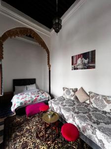 een slaapkamer met een bed en een bank erin bij Riad Palais D'Or in Rabat