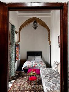 een slaapkamer met een bed en een rode stoel bij Riad Palais D'Or in Rabat