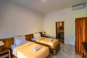 1 dormitorio con 2 camas y espejo en Mina Tanjung Hotel en Tanjung