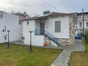 a white house with a red door and a yard at Filipa Gardens in Limenas