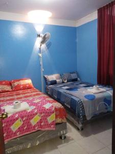 1 dormitorio con 2 camas y lámpara de pie en Hospedaje EDUCOL en Moyobamba