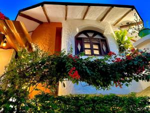 Casa del Lago Lodging House في بويرتو أيورا: مبنى به نافذة عليها زهور