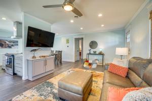 sala de estar con sofá y TV de pantalla plana en Wrightsville Beach Home with Fenced Yard en Wrightsville Beach