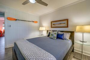 a bedroom with a bed with blue sheets and two lamps at Wrightsville Beach Home with Fenced Yard in Wrightsville Beach