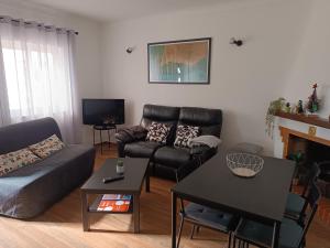 ein Wohnzimmer mit einem Sofa und einem Tisch in der Unterkunft Casa Zeferino in Ferragudo