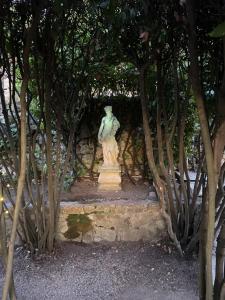 una estatua de una mujer sentada en una pared de piedra en Bastide Aïna SPA et piscine, en Grasse