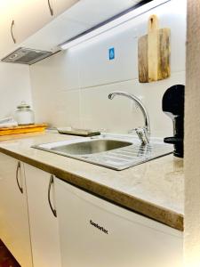 eine Küche mit einer Spüle und einer Theke in der Unterkunft Casa46 in Olhão