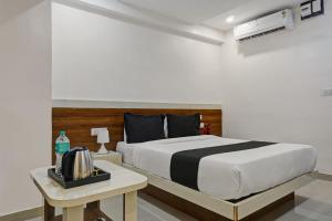 a bedroom with a bed and a table with a phone at Collection O Hotel Stay Prime Baner in Pune
