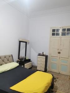 1 dormitorio con 1 cama con manta amarilla en Dar mima baya en Túnez