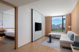 a hotel room with a bed and a couch and a tv at Fairfield by Marriott Bijie in Bijie