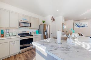 a kitchen with white cabinets and a marble counter top at Eternal Sunshine in Dover