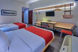 a hotel room with two beds and a desk at City Express by Marriott Chihuahua in Chihuahua