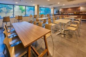 une salle de classe avec des tables et des chaises dans une cafétéria dans l'établissement City Express by Marriott Chihuahua, à Chihuahua