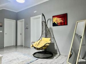a room with a swinging chair with a mirror at Vila 007 in Velipojë