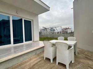 a white table and chairs on a balcony at Vila 007 in Velipojë