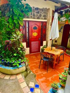 Cette chambre comprend une porte rouge, une table et des chaises. dans l'établissement Casa del Lago Lodging House, à Puerto Ayora
