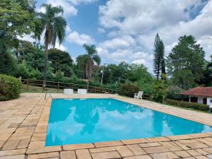 una piscina de agua azul en un patio en Chacara Recanto Paraíso Guacuri 2 en Itupeva