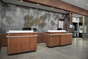 a lobby with reception desks and a chandelier at Courtyard by Marriott Northport in Northport