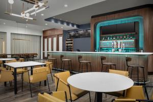 a restaurant with tables and chairs and a bar at Courtyard by Marriott Northport in Northport