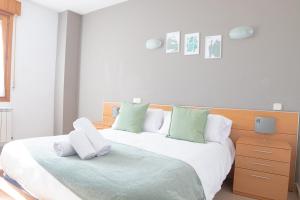 una camera con 2 letti con cuscini bianchi e verdi di Hostal-Casa Rural Rosa-Nonna a Sigüenza