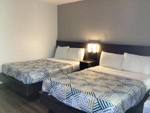 two beds sitting next to each other in a room at Motel 6-Reno, NV - Livestock Events Center in Reno +16 photos