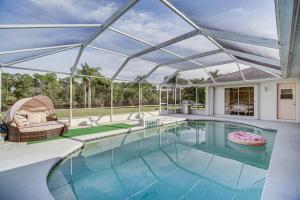 een binnenzwembad met een groot glazen plafond bij Port St Lucie Canal-Front Home with Private Pool! in Port Saint Lucie