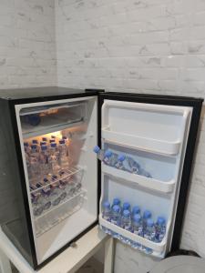 an open refrigerator filled with drinks and water bottles at روز حي الربوه في الرياض in Riyadh