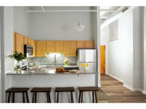 uma cozinha com armários de madeira e um balcão com bancos em Modern Apartment Close To Everything CozySuites em Indianápolis