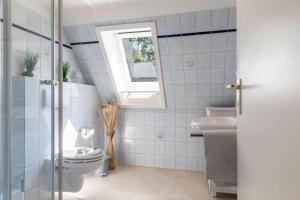 ein Bad mit einem WC und einem Fenster in der Unterkunft Villa Magnolia H in Hohwacht