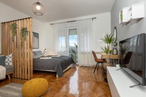 a bedroom with a bed and a desk and a television at Apartman Roza in Zagreb