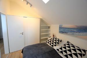 - une chambre avec un lit et un placard blanc dans l'établissement Meeresblick-Strandkorb-Haus-3-WE-46, à Hohwacht
