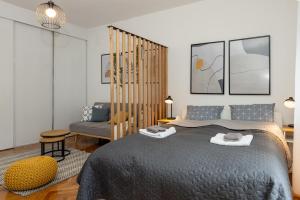 a bedroom with a large bed and a chair at Apartman Roza in Zagreb