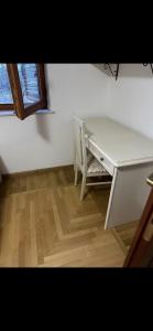 a white desk and a chair in a room at Fine house in Marginea