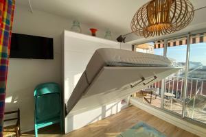 een groot wit bed in een kamer met een groot raam bij Nice studio near the sea in Arcachon