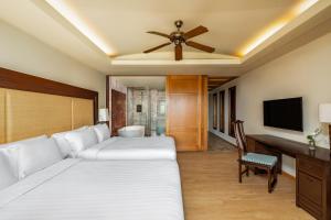 1 dormitorio con 2 camas y ventilador de techo en Centara Grand Beach Resort Phuket - SHA Plus en Karon