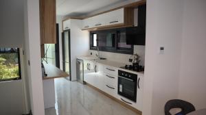 a kitchen with white cabinets and black appliances at Villa Dream Kuşadası Pool- Garage in Kusadası