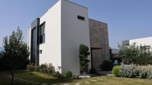 ein weißes Haus mit einem Garten davor in der Unterkunft Villa Dream Kuşadası Pool- Garage in Kusadası