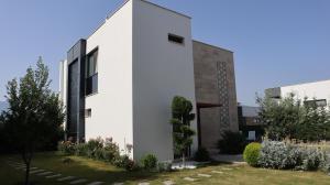a white house with a garden in front of it at Villa Dream Kuşadası Pool- Garage in Kuşadası