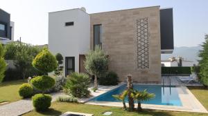a house with a swimming pool in front of it at Villa Dream Kuşadası Pool- Garage in Kuşadası