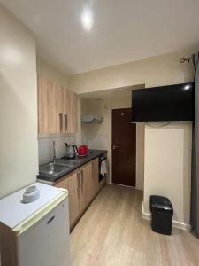 een keuken met een wastafel en een aanrecht bij Cosy Studio Flat in Londen