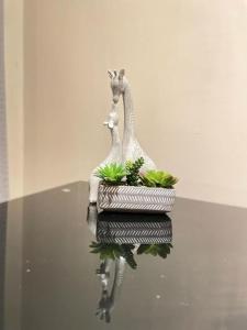 a figurine of two giraffes and plants on a table at Cosy Studio Flat in London