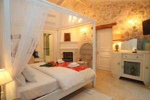 1 dormitorio con cama blanca y chimenea en The Aigli, en Lefkada