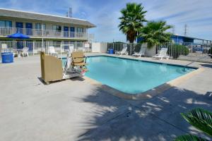 una gran piscina con sillas y un edificio en Motel 6-Galveston, TX, en Galveston