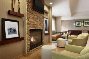 a living room with a fireplace and a dining room at Hampton Inn Denville-Rockaway-Parsippany in Denville